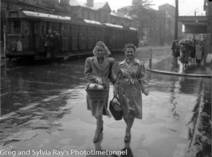 Women on the corner of Hunter and Bolton Streets, Newcastle, on a rainy day, circa 1940s.
