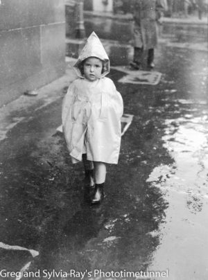 Child in a raincoat in Newcastle, circa 1940s.