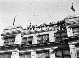 Confetti raining from the Newcastle Herald building. Celebrations in Newcastle, NSW, for the end of World War 2, August 15, 1945.