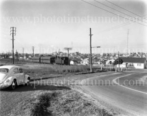 Passenger train at railway level crossing at Adamstown NSW, 1960s.