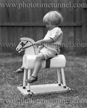 Child on a wooden hobby horse, circa 1900.