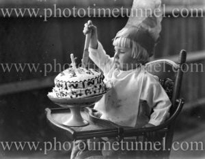 Child with a birthday cake, circa 1900.