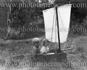 Children in a toy sailboat, circa 1900.
